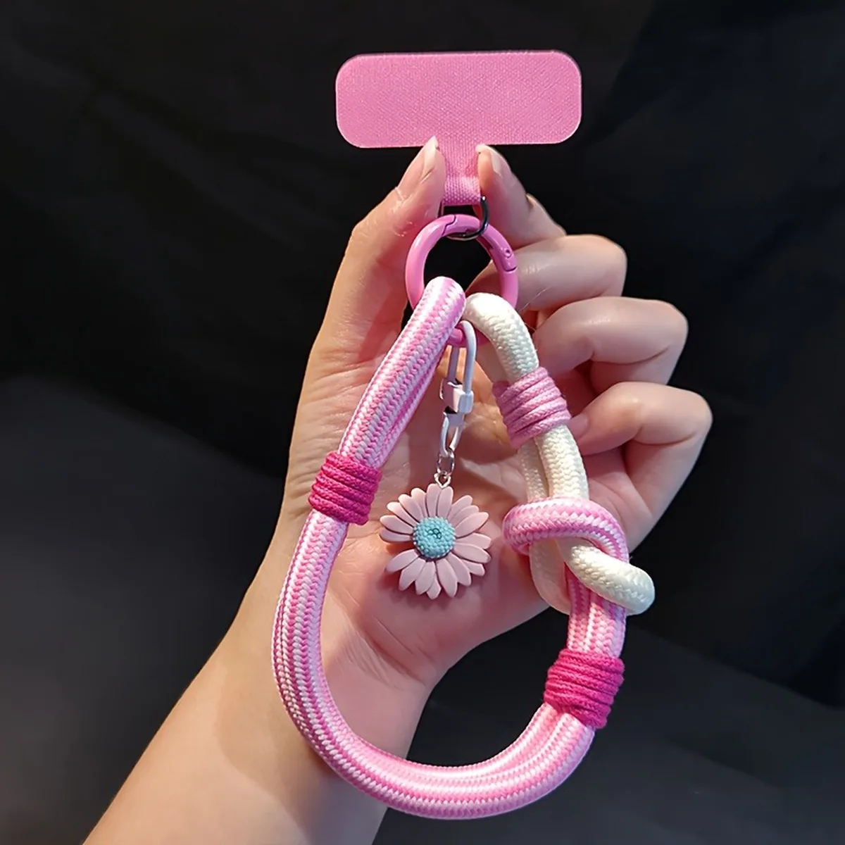 יד מחזיקה רצועת יד ורודה-לבנה לטלפון עם תליון פרח